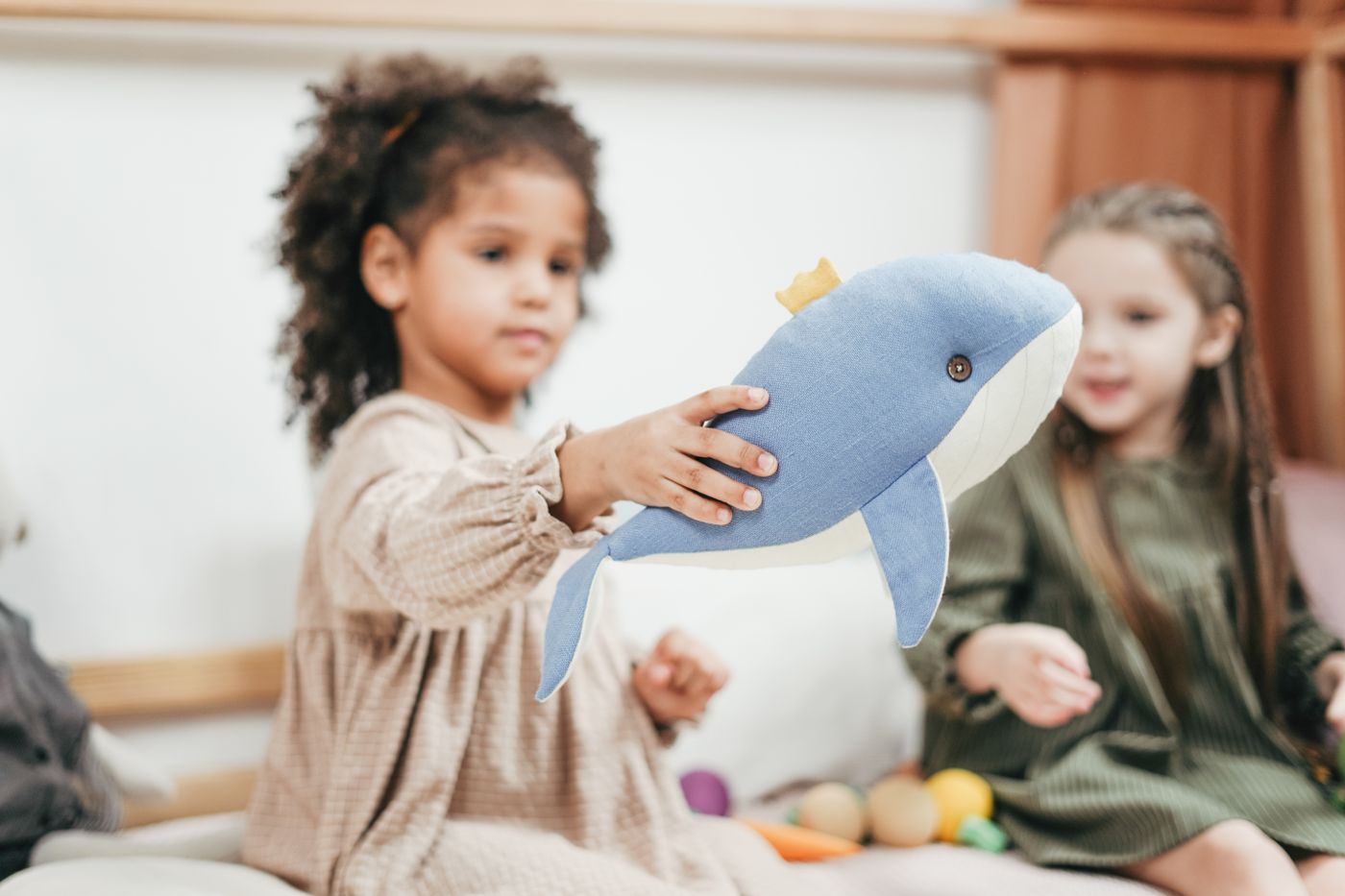 Child playing with a toy in a bright classroom
