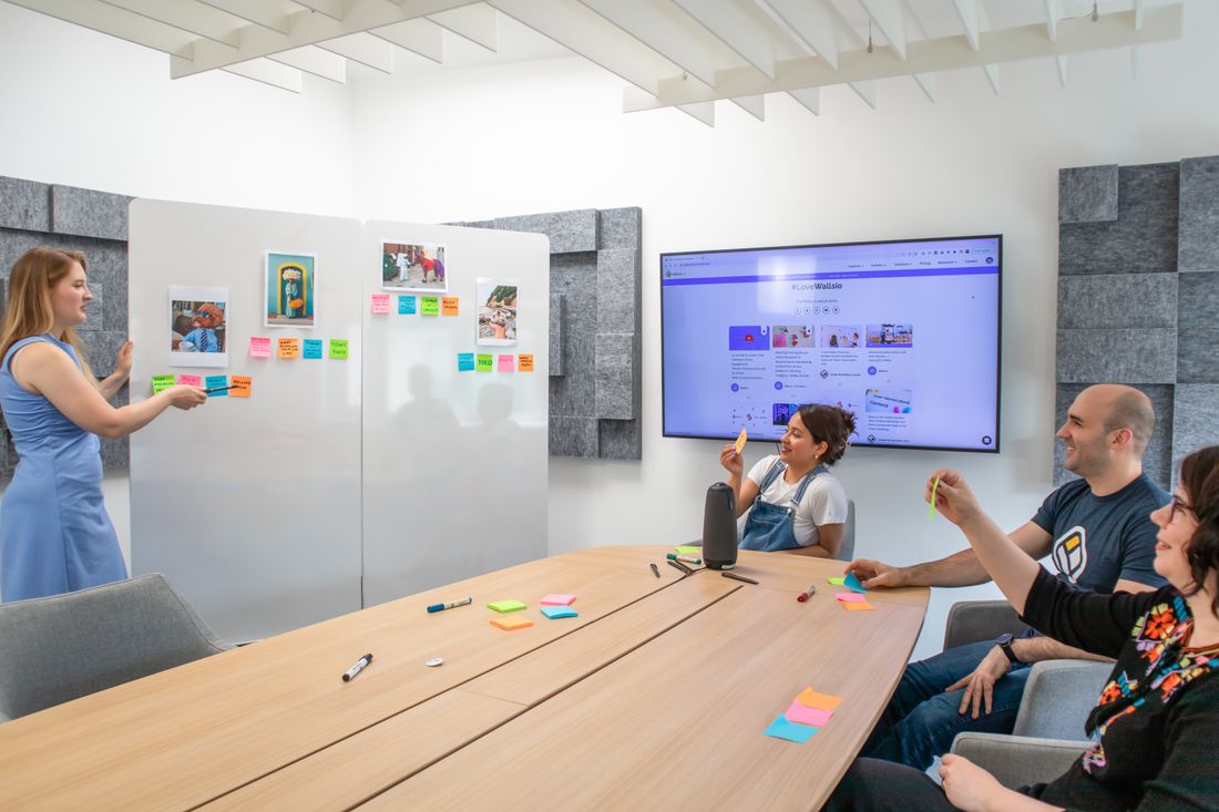 A team gathered around a whiteboard covered in sticky notes during a planning session