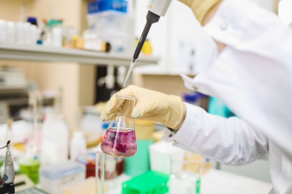 A researcher pipetting a sample in a laboratory