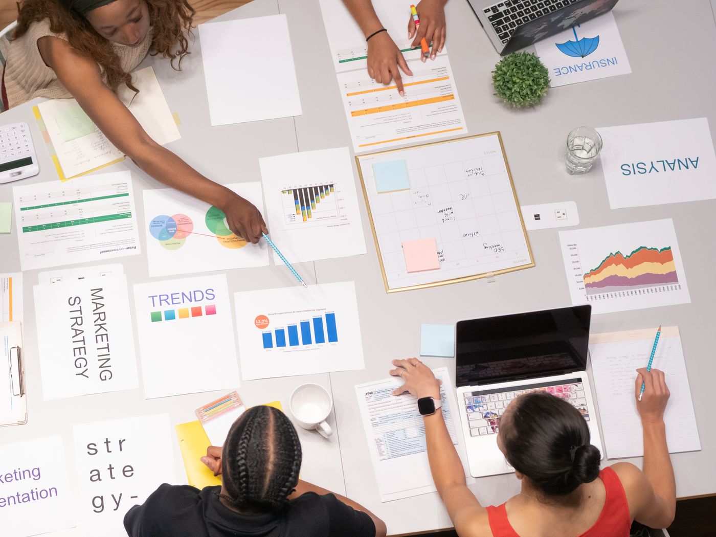 Marketing strategy, trends, and analysis papers spread on a table