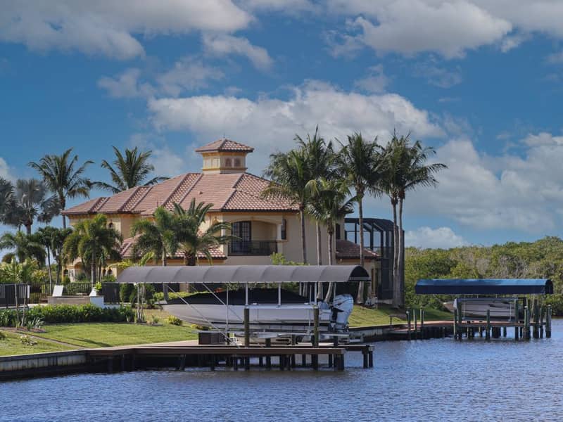Canal-front home with a boat lift and palm trees