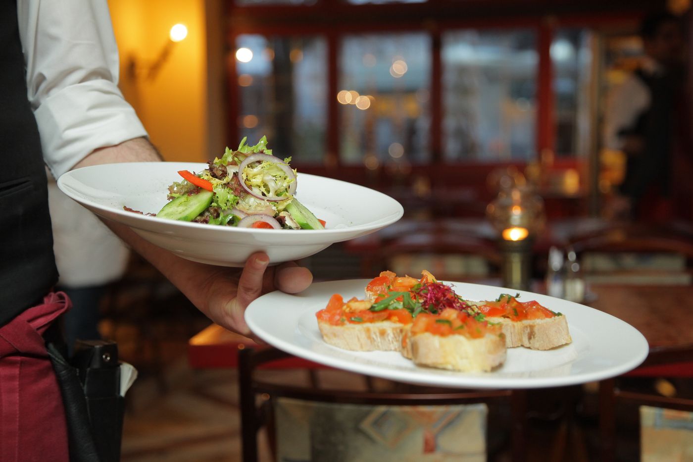 Server plating dishes in a restaurant
